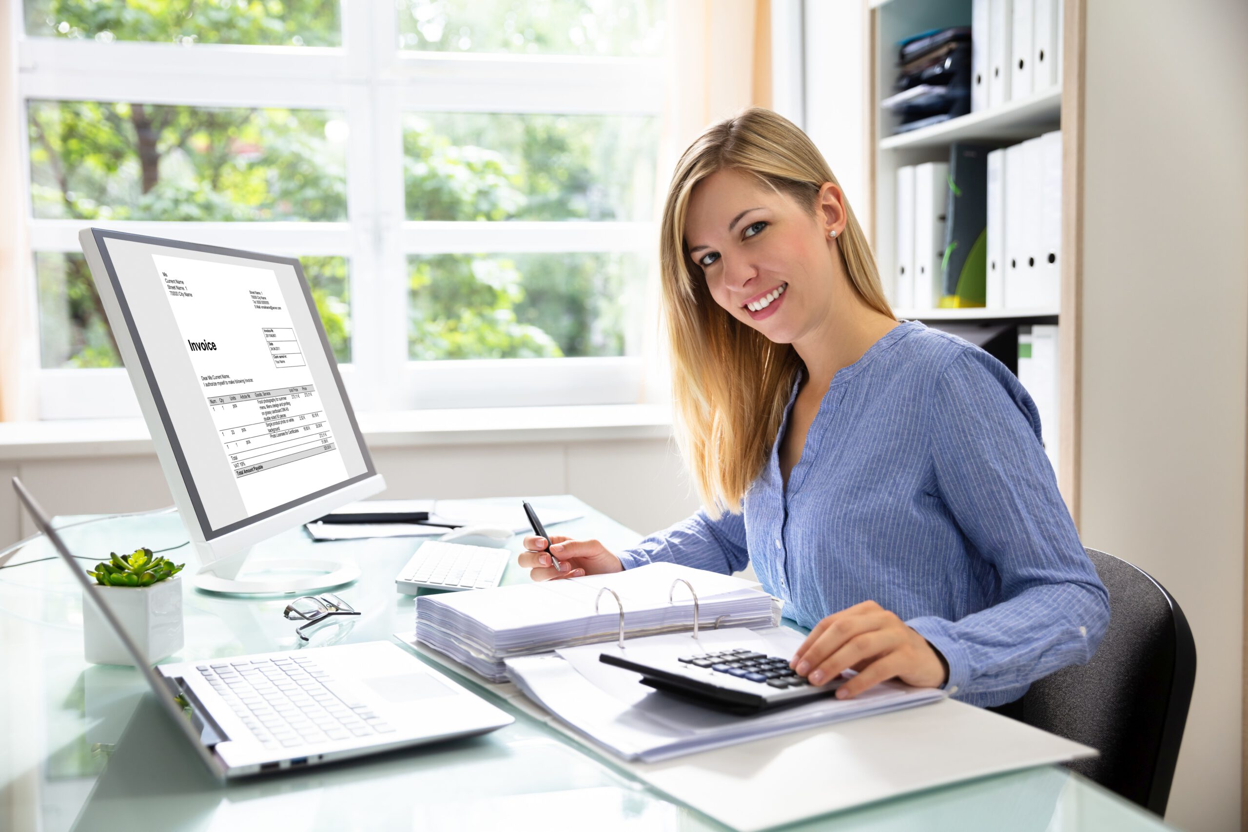 Young Businesswoman Calculating Bill In Office