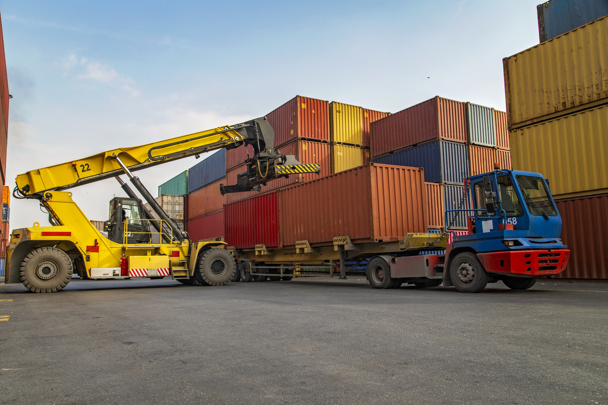 Crane lifting up container in a port.